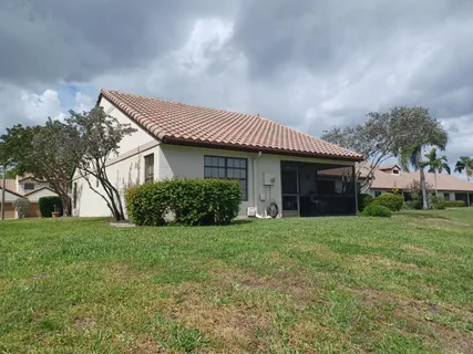 a front view of a house with a garden and trees