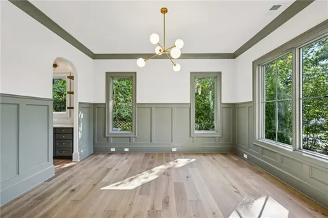 a view of an empty room with a window and kitchen view