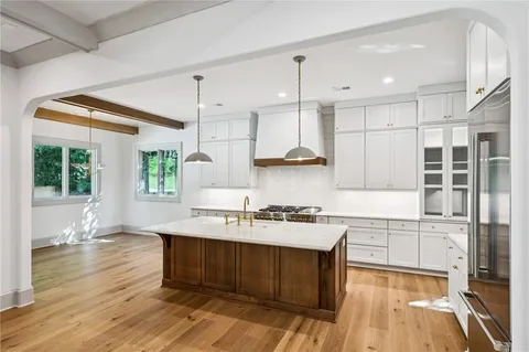 a kitchen with wooden floors and white cabinets