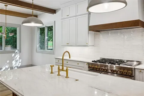 a kitchen with stainless steel appliances granite countertop a sink and a stove