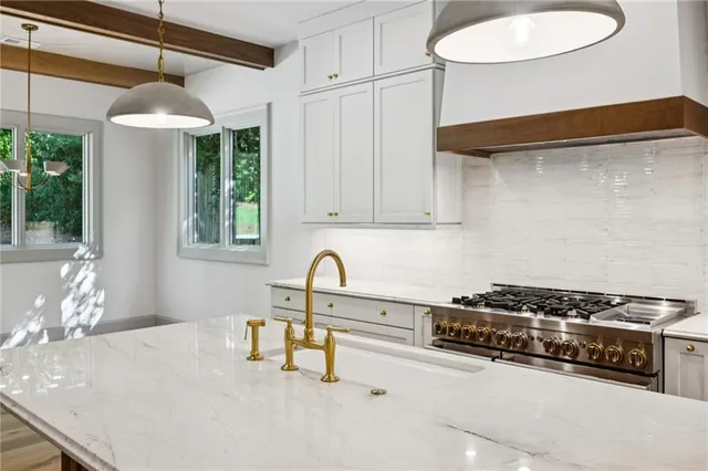 a kitchen with stainless steel appliances granite countertop a sink and a stove