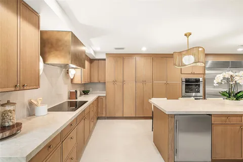 a large kitchen with a sink and a wooden floor
