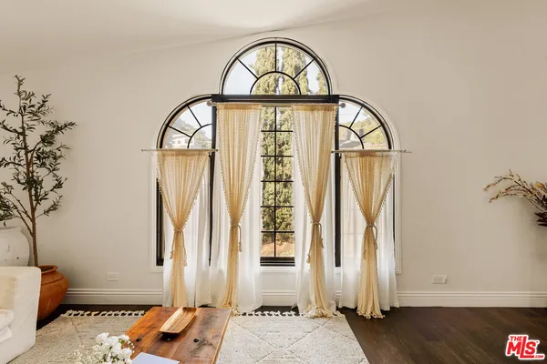 a view of a livingroom with wooden floor and a window