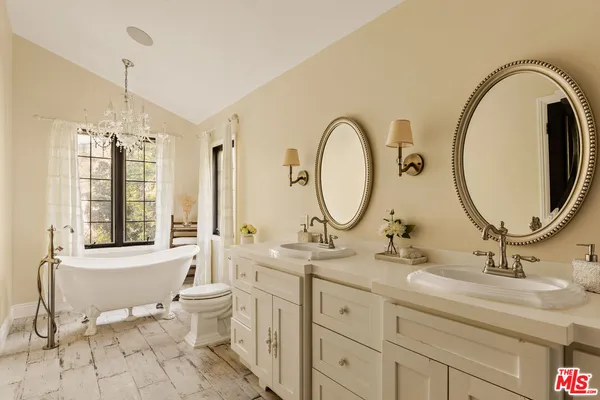 a bathroom with a double vanity sink mirror and a toilet