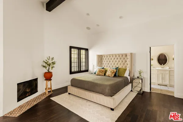 a bedroom with a bed a fireplace and dresser