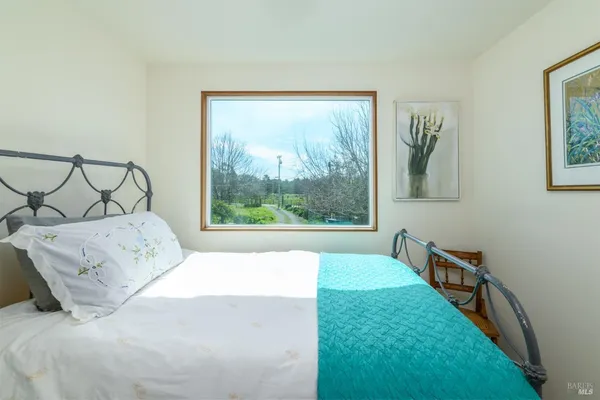 a bed sitting in a bedroom next to a window