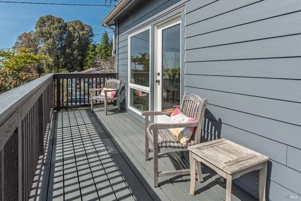 a balcony with wooden floor table and chairs