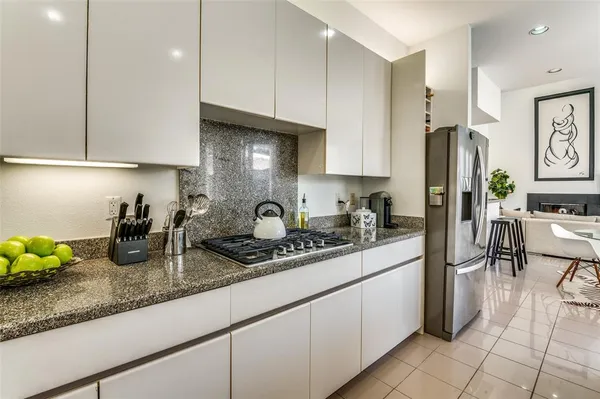 a kitchen with granite countertop a sink a stove and a refrigerator
