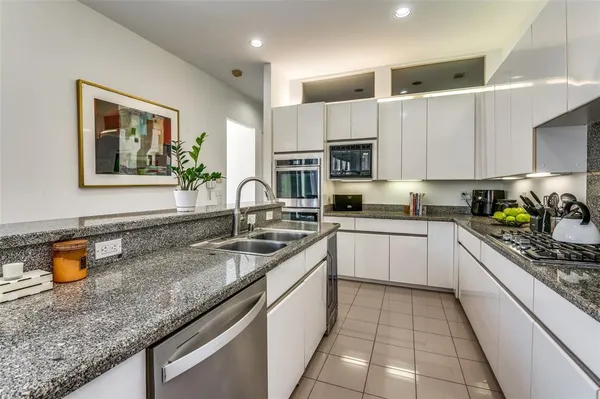 a kitchen with stainless steel appliances granite countertop a sink stove and cabinets