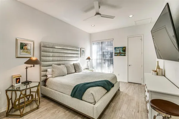 a bedroom with a bed a mirror and lamp