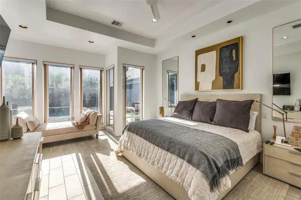 a spacious bedroom with a bed and glass walk in closet