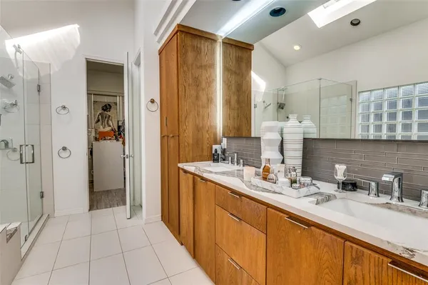 a bathroom with a double vanity sink a mirror and shower
