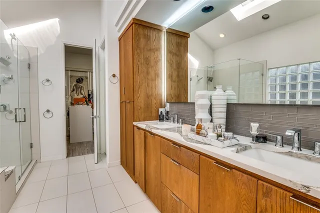 a bathroom with a double vanity sink a mirror and shower