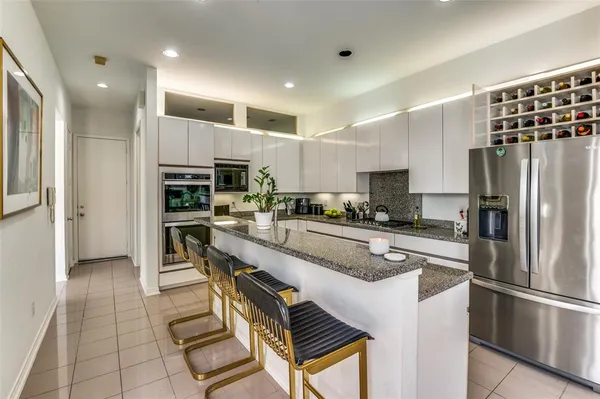a kitchen with stainless steel appliances a refrigerator sink and microwave