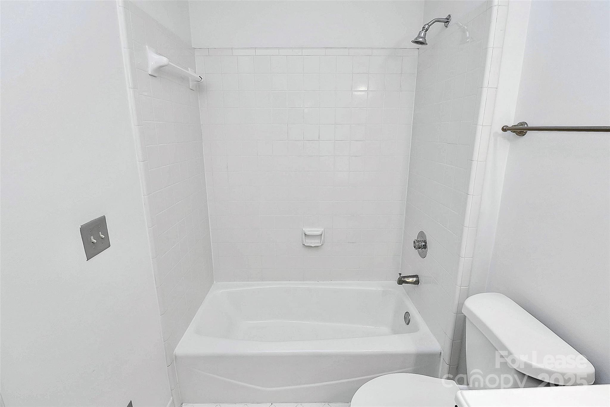 2220 Roswell Avenue, Unit A Charlotte, NC 28207 - Photo 15 of 34 a bathroom with a bathtub and a toilet