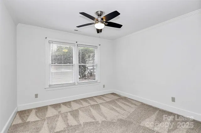 an empty room with ceiling fan and window