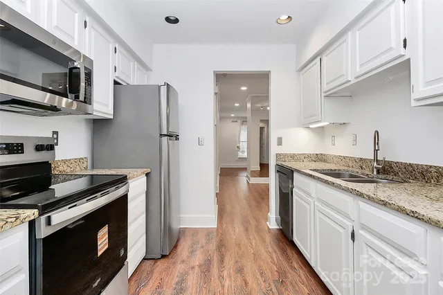 a kitchen with stainless steel appliances granite countertop a stove a sink and a refrigerator
