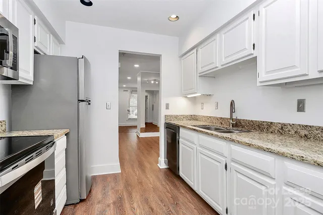 a kitchen with stainless steel appliances granite countertop a refrigerator and a stove top oven