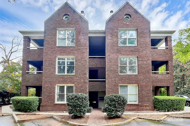 front view of a brick house with a yard