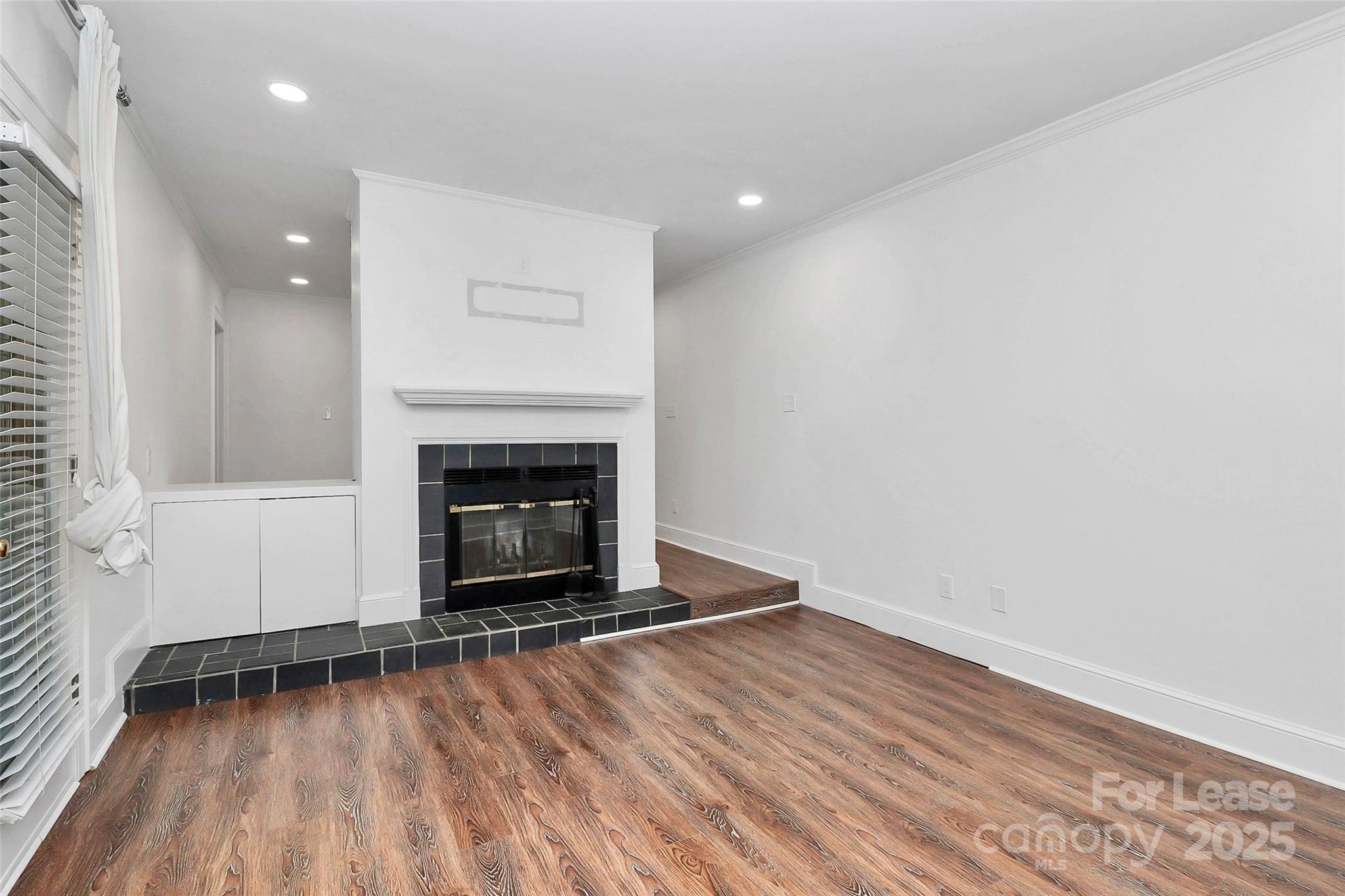 2220 Roswell Avenue, Unit A Charlotte, NC 28207 - Photo 6 of 34 a view of empty room with wooden floor and fireplace