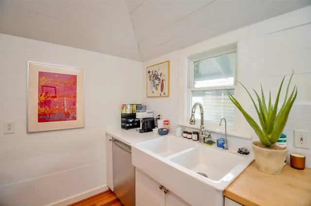 a bathroom with a sink a mirror and a potted plant