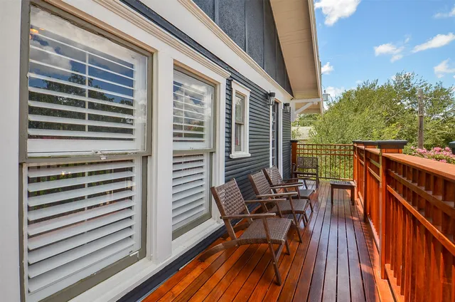 a view of balcony with chairs and wooden fence