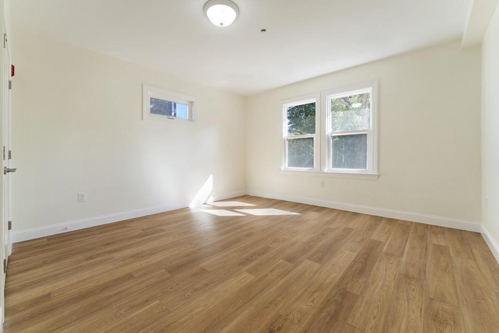 27 Perrin Street, Unit 1 Boston, MA 02119 - Photo 12 of 22 an empty room with wooden floor and windows