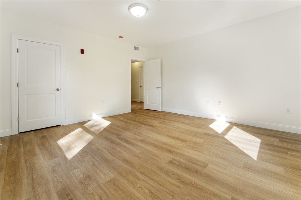 27 Perrin Street, Unit 1 Boston, MA 02119 - Photo 17 of 22 a view of an empty room and wooden floor