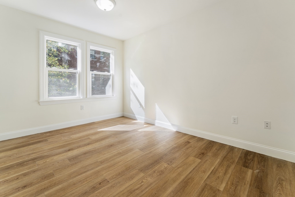 27 Perrin Street, Unit 1 Boston, MA 02119 - Photo 19 of 22 an empty room with wooden floor and windows