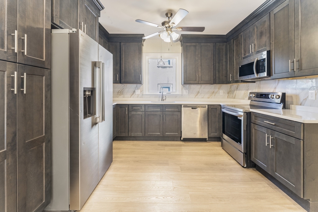 27 Perrin Street, Unit 1 Boston, MA 02119 - Photo 4 of 22 a large kitchen with cabinets and stainless steel appliances