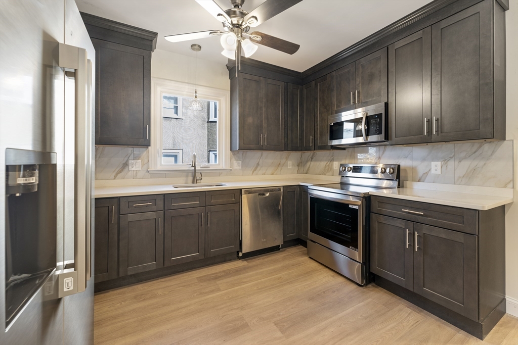 27 Perrin Street, Unit 1 Boston, MA 02119 - Photo 6 of 22 a kitchen with a sink cabinets and stainless steel appliances