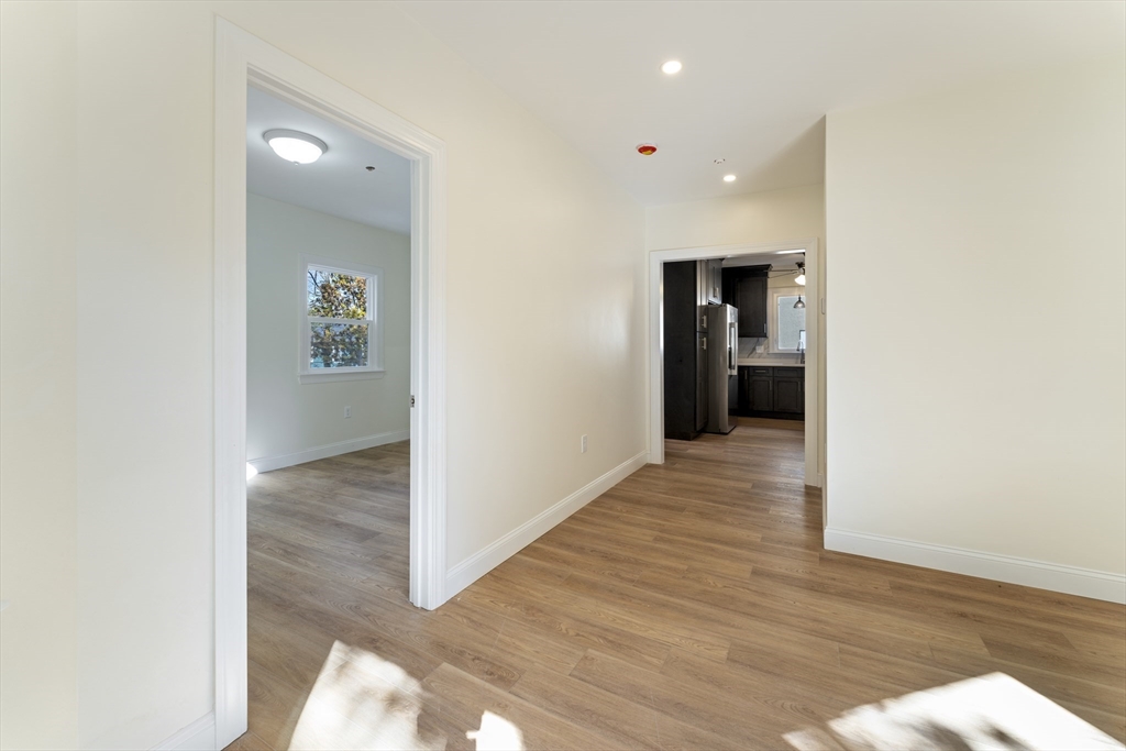 27 Perrin Street, Unit 1 Boston, MA 02119 - Photo 9 of 22 a view of a hallway with wooden floor and a living room