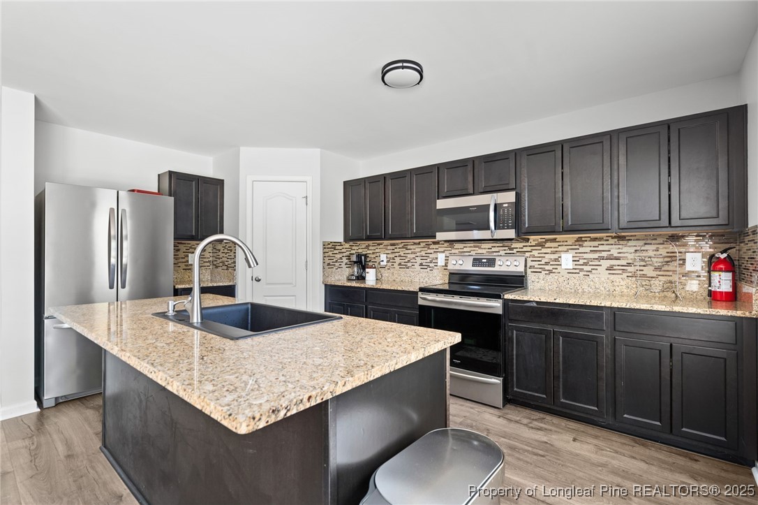 5926 Lowgrass Road Stedman, NC 28391 - Photo 13 of 39 a kitchen with granite countertop a sink stove and refrigerator