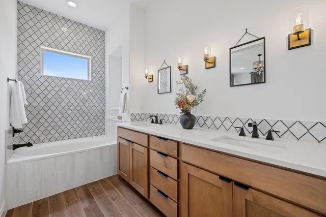 a bathroom with a bathtub sink and mirror