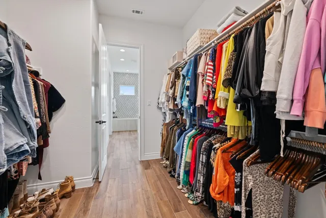 a view of walk in closet with clothes and shoes