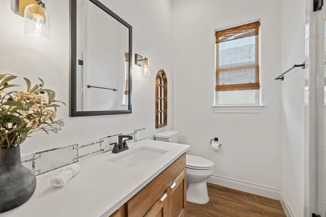 a bathroom with a sink vanity granite and toilet