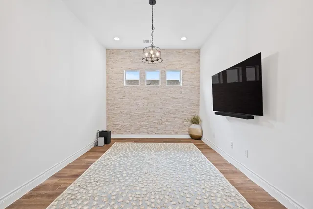 a view of a livingroom with wooden floor and a flat screen tv
