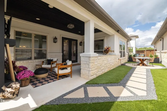 a view of a patio with couches table and chairs and potted plants