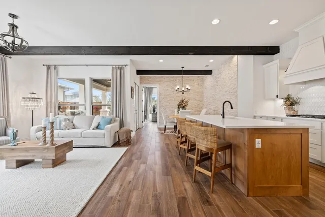 a very nice looking dining room with kitchen island a large window and stainless steel appliances