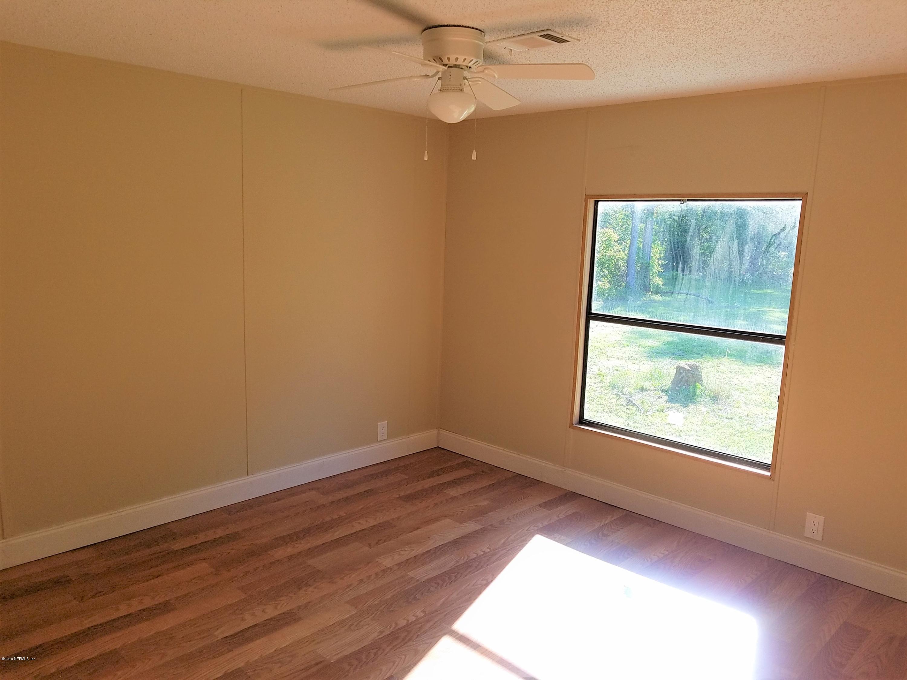 2801 Green Acres Road, Unit EXTENSION St. Augustine, FL 32084 - Photo 11 of 30 an empty room with wooden floor and windows