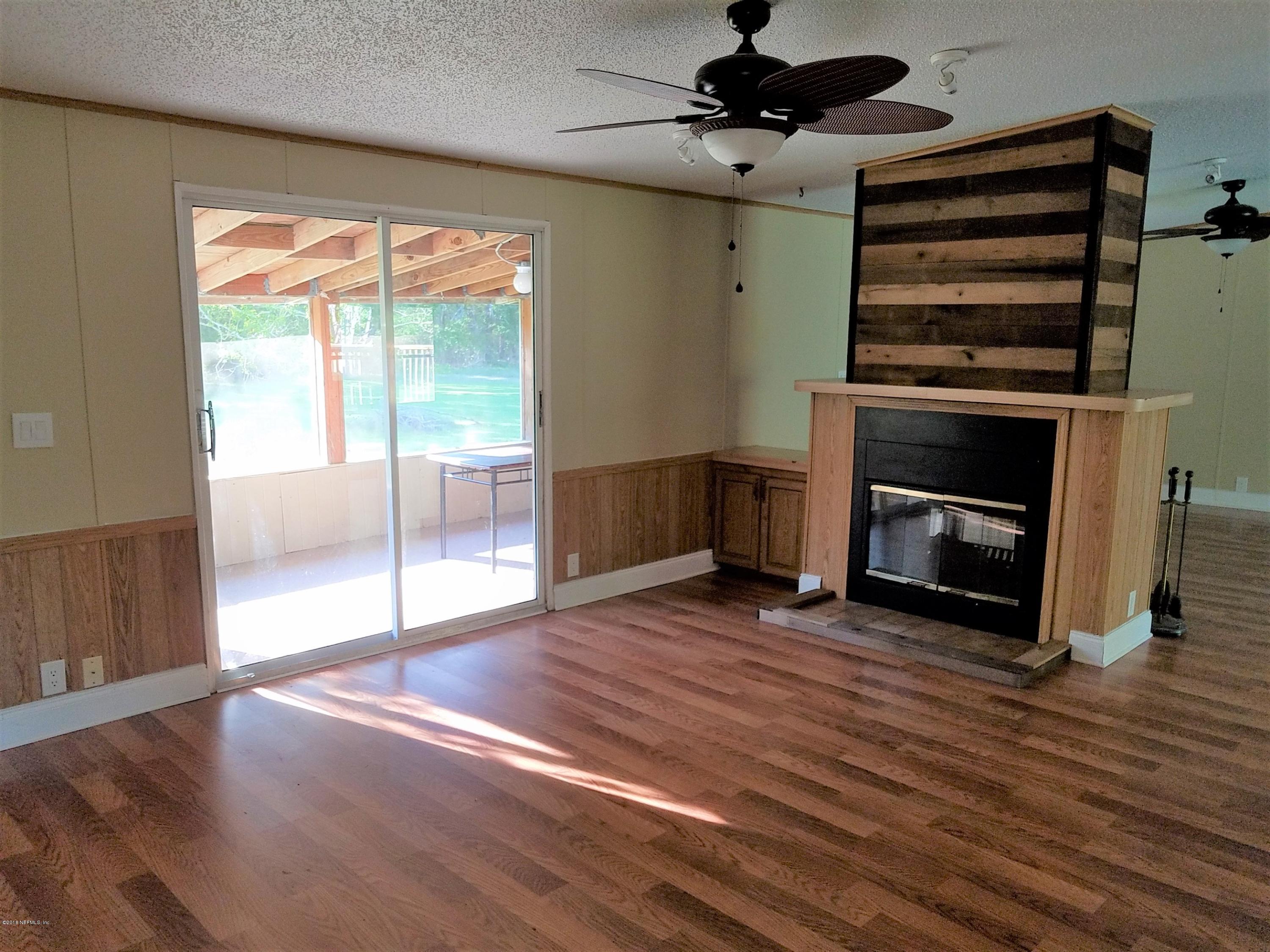 2801 Green Acres Road, Unit EXTENSION St. Augustine, FL 32084 - Photo 23 of 30 an empty room with wooden floor fireplace and windows