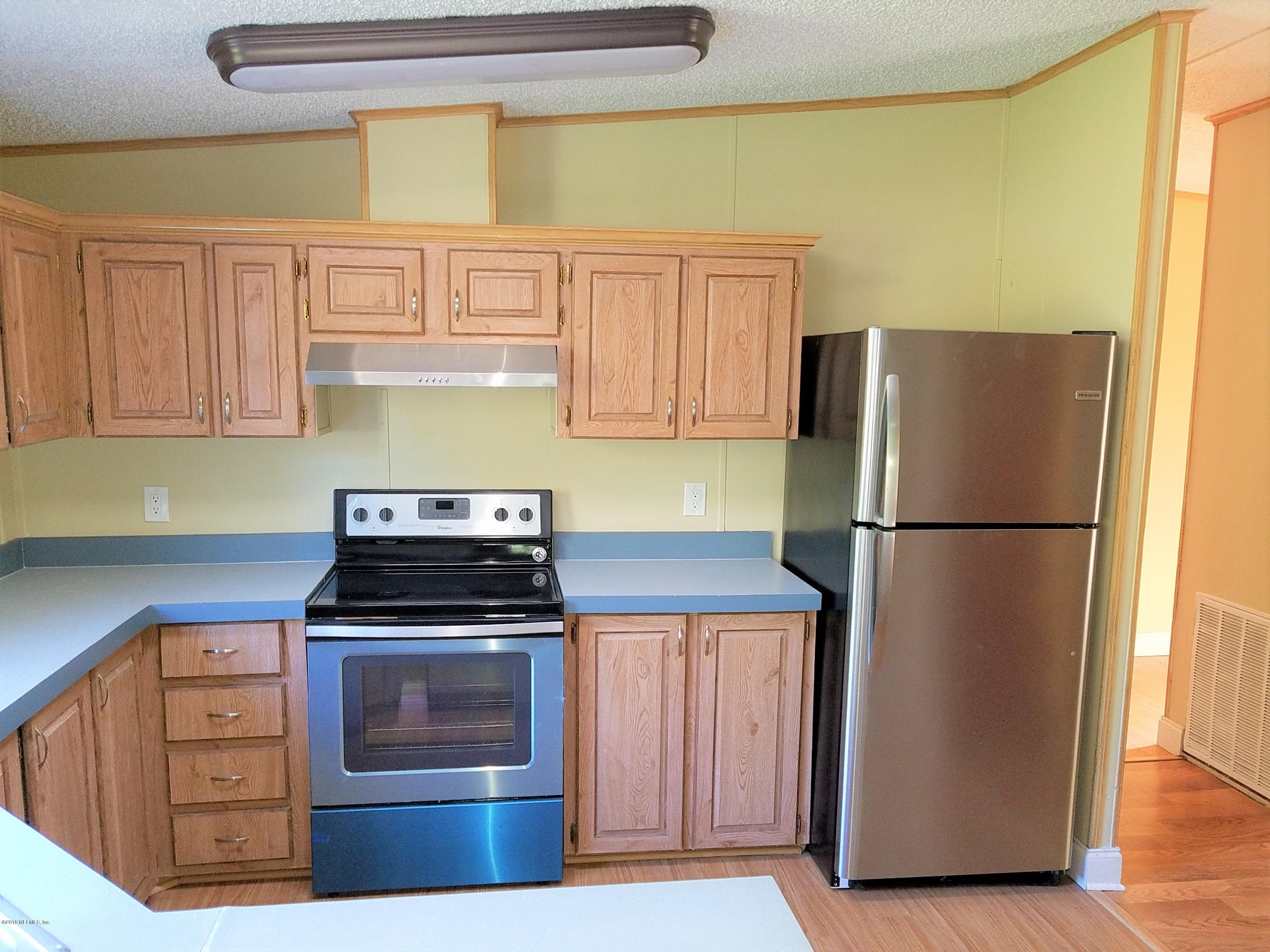 2801 Green Acres Road, Unit EXTENSION St. Augustine, FL 32084 - Photo 25 of 30 a kitchen with refrigerator a stove and a window