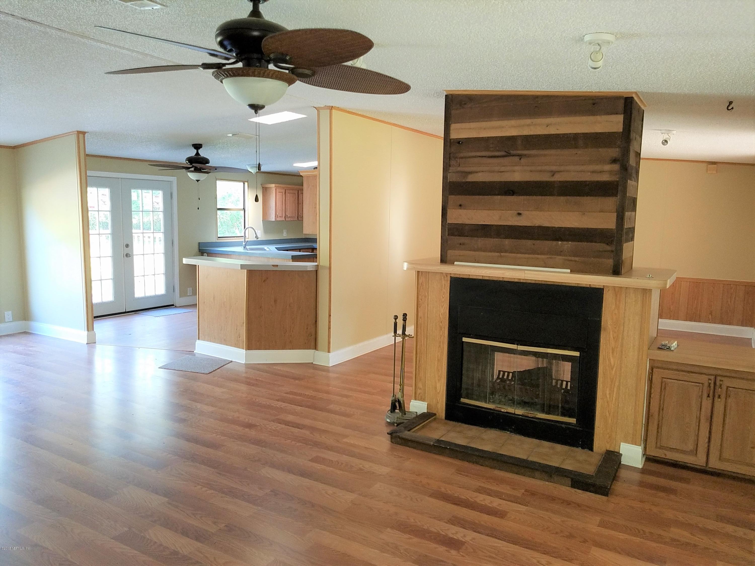 2801 Green Acres Road, Unit EXTENSION St. Augustine, FL 32084 - Photo 7 of 30 a view of an empty room with wooden floor a fireplace and a window