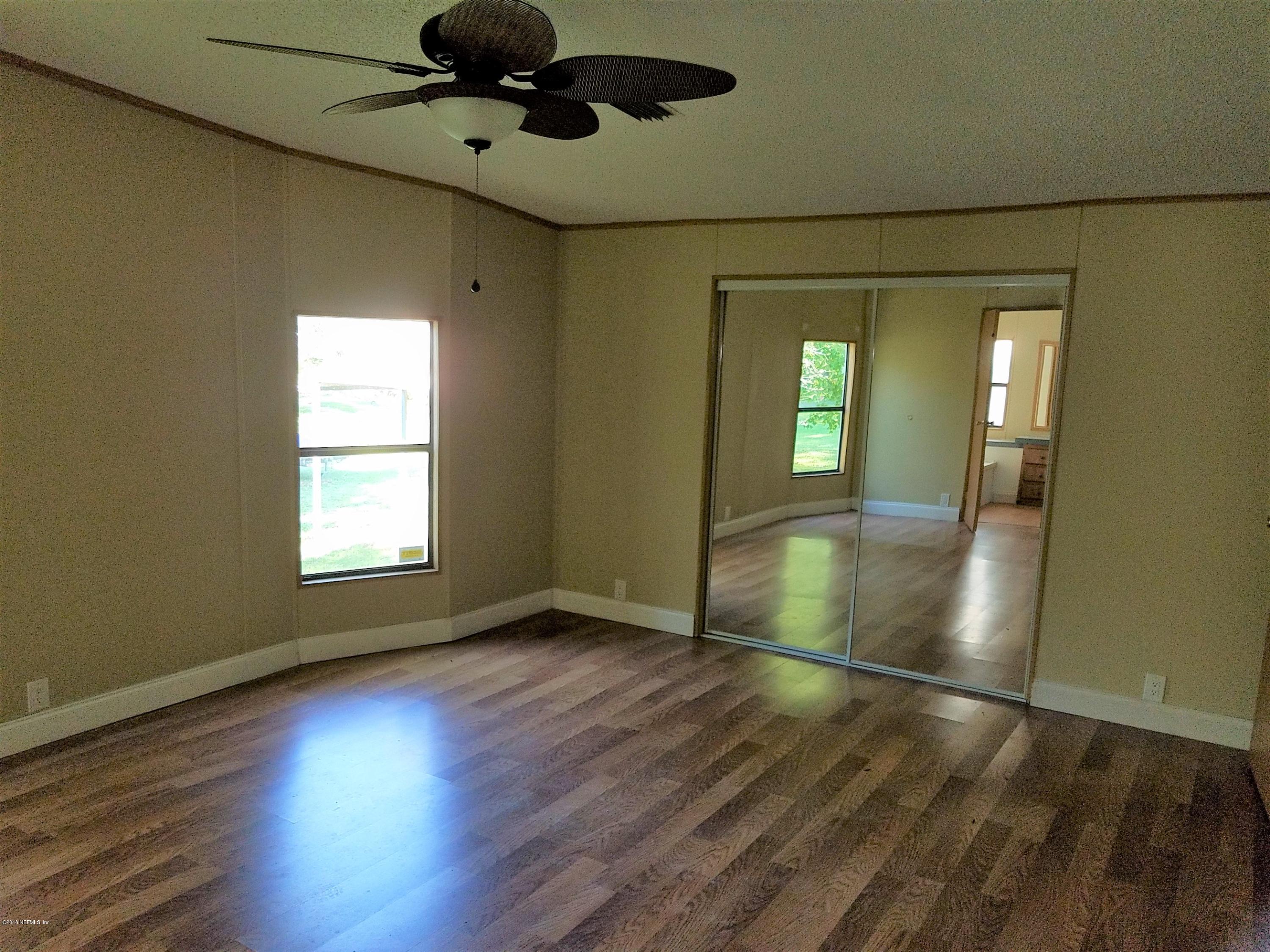 2801 Green Acres Road, Unit EXTENSION St. Augustine, FL 32084 - Photo 9 of 30 an empty room with wooden floor and windows