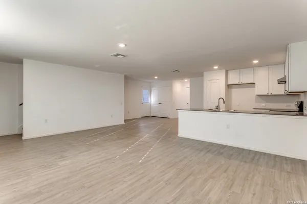 a view of kitchen with kitchen island white cabinets and wooden floor