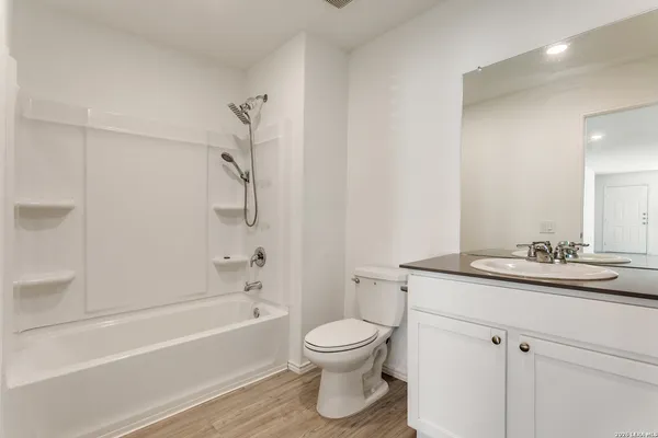 a bathroom with a granite countertop sink a toilet and a bathtub