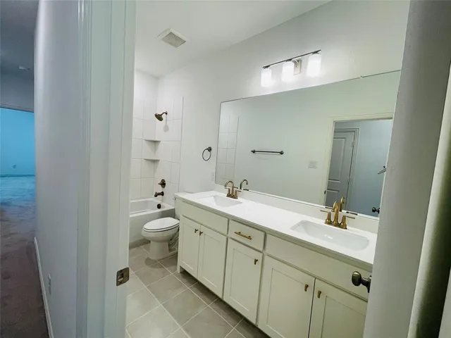 a spacious bathroom with a double vanity sink mirror and toilet