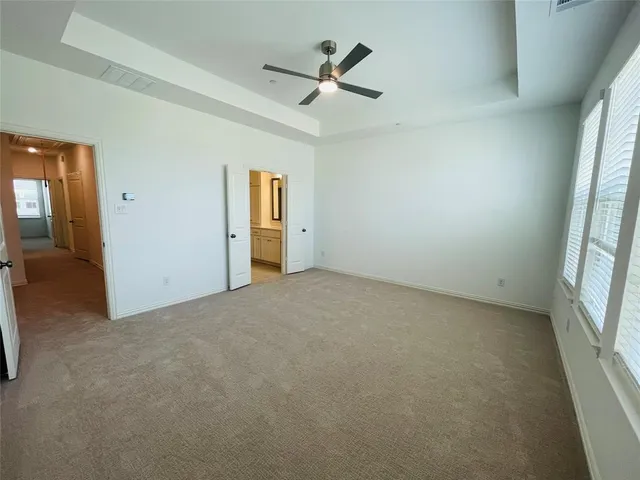 an empty room with a ceiling fan and window