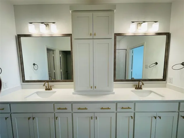 a bathroom with double vanity sinks and a mirror
