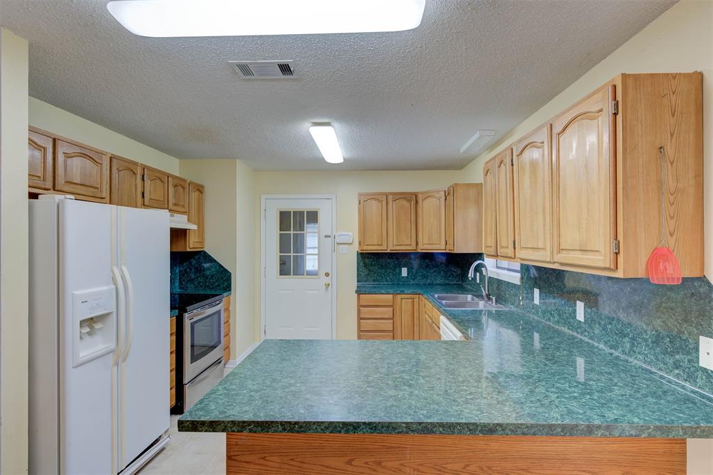 119 Beech Street Homer, LA 71040 - Photo 12 of 21 a kitchen with stainless steel appliances granite countertop a refrigerator a stove and a sink with granite countertops